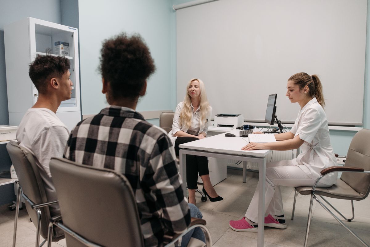 Equipo m&eacute;dico conversando con pacientes en la cl&iacute;nica